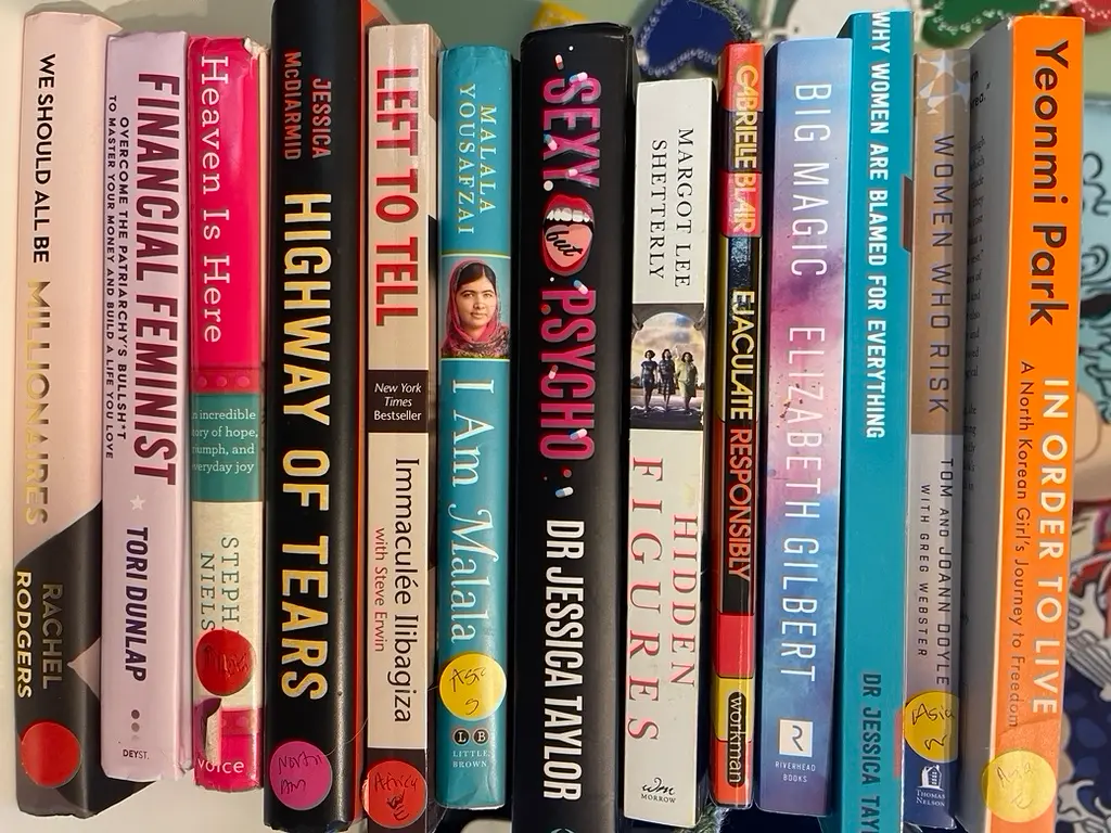 A row of empowering books for women sits on a shelf, ready to read.
